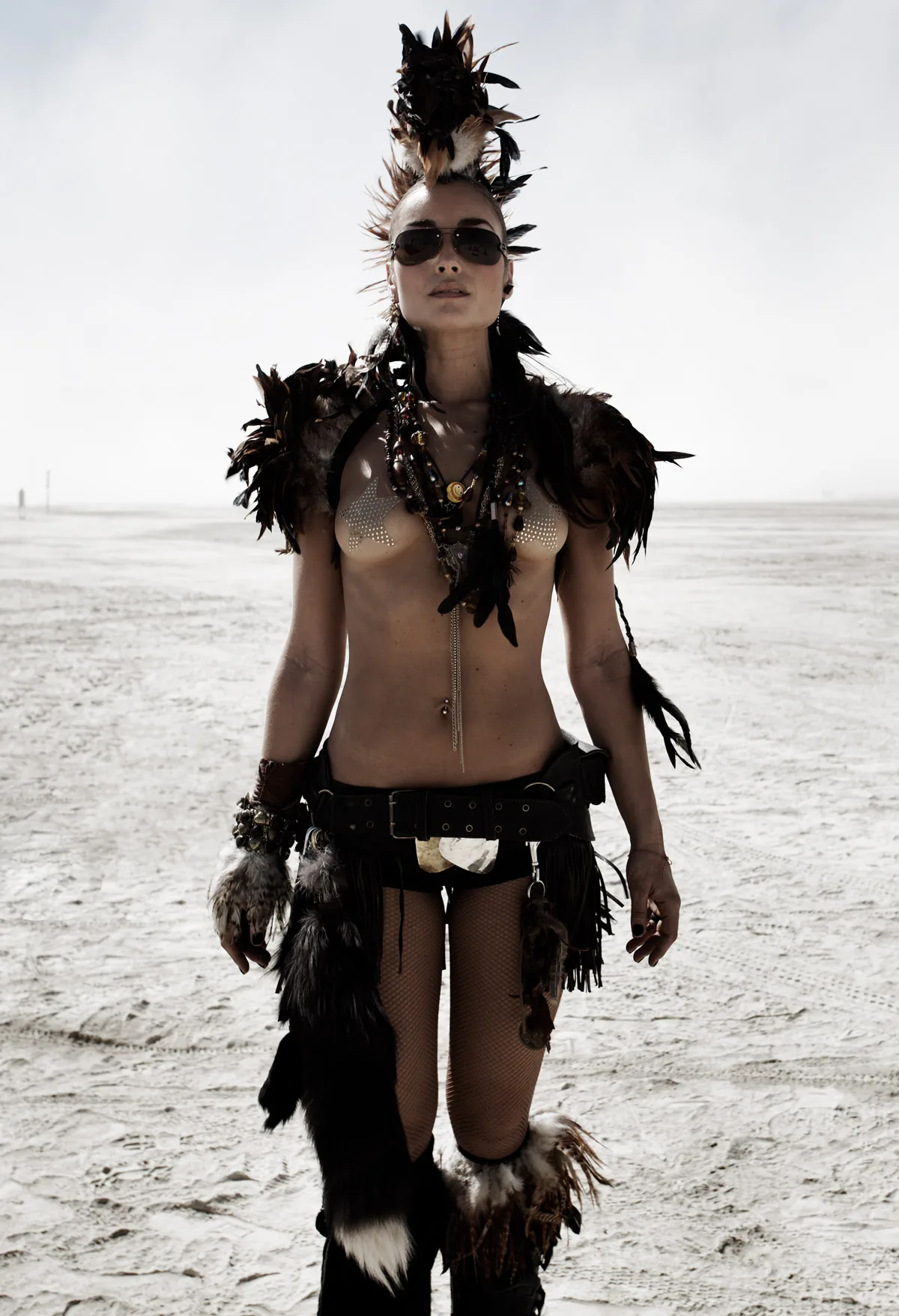 A woman in a feathered costume and crest headdress on the playa