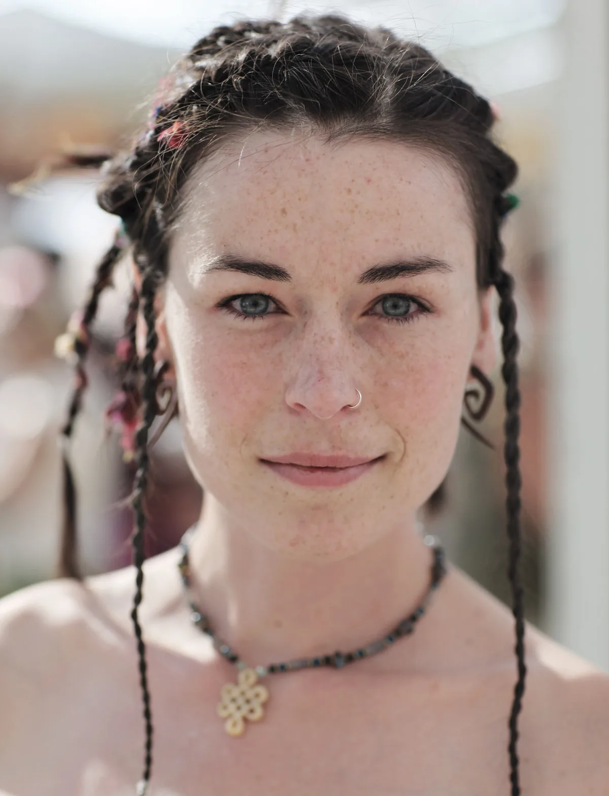 Portrait of a woman with braided hair and a pendant necklace