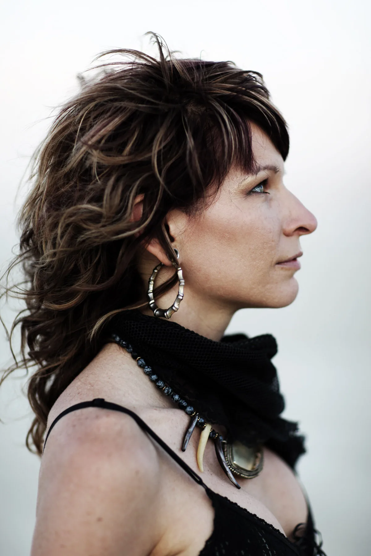 Profile portrait of a woman with dark hair and a black scarf